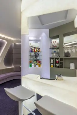 a bar with a white counter and a stool at V Hotel Dubai, Curio Collection by Hilton in Dubai