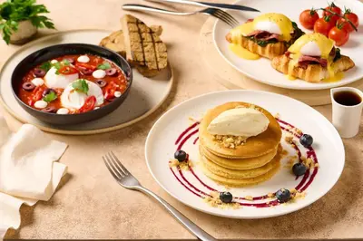 a table with plates of food and a bowl of soup at Hilton Dubai Al Habtoor City in Dubai