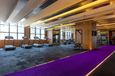 a gym with purple mats and a row of exercise bikes at Hilton Dubai Al Habtoor City in Dubai