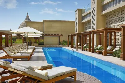 a swimming pool with lounge chairs and a building at Hilton Dubai Al Habtoor City in Dubai
