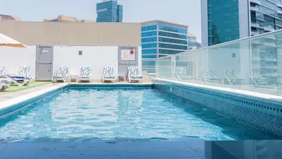 a swimming pool on top of a building with chairs at Signature 1 Hotel Tecom in Dubai