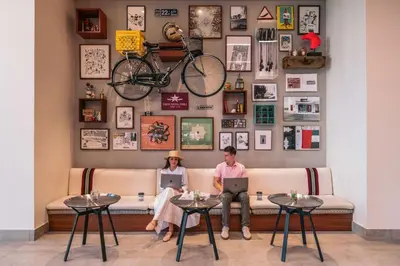 two people sitting on a couch with their laptops at Rove Downtown in Dubai