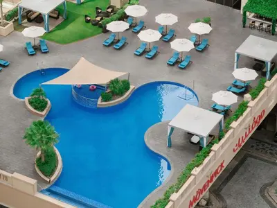 an overhead view of a resort pool with tables and umbrellas at Mövenpick Hotel Jumeirah Beach in Dubai