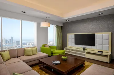 a living room with a couch and a tv at La Suite Dubai Hotel & Apartments in Dubai