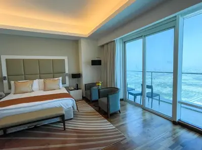a bedroom with a bed and a large window at La Suite Dubai Hotel & Apartments in Dubai