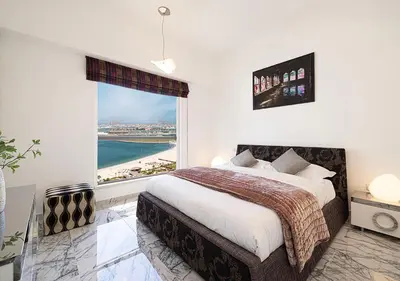 a bedroom with a large bed and a large window at Luxury Sea View Beachfront 3 Bedroom Apt, JBR in Dubai