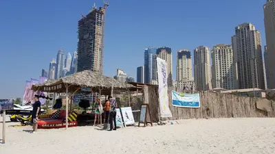 a group of people standing on a beach with a tent at Luxury Sea View Beachfront 3 Bedroom Apt, JBR in Dubai