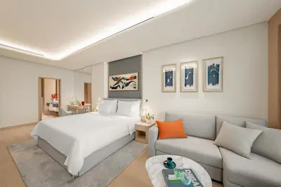 a hotel room with a bed and a couch at The Meydan Hotel Dubai in Dubai