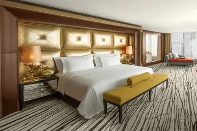 a bedroom with a large bed and a yellow bench at The Meydan Hotel Dubai in Dubai