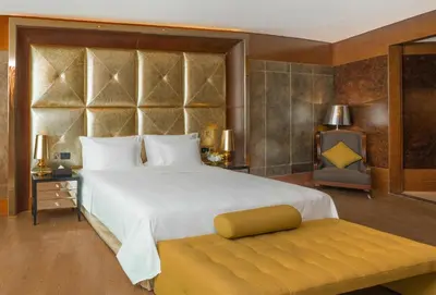 a bedroom with a large white bed and a bench at The Meydan Hotel Dubai in Dubai