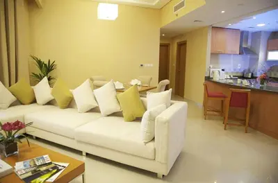 a living room with a white couch with yellow pillows at Grand Bellevue Hotel Apartment Dubai in Dubai