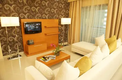 a living room with a white couch and a tv at Grand Bellevue Hotel Apartment Dubai in Dubai
