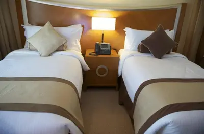 a hotel room with two beds and a lamp at Grand Bellevue Hotel Apartment Dubai in Dubai