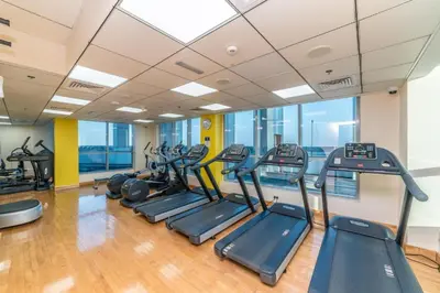 a gym with a bunch of treadmills at One Bedroom Apartment - Bay Central Tower in Dubai