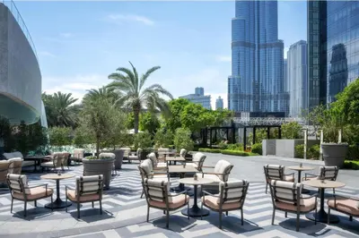 a patio with tables and chairs and a city skyline at Kempinski The Boulevard Dubai in Dubai