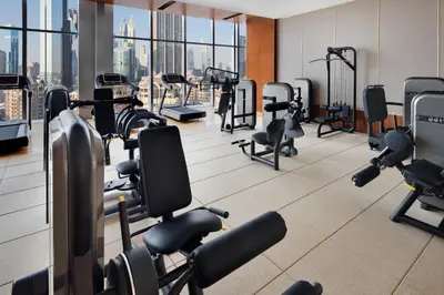 a gym with a lot of treadmills and machines at Kempinski The Boulevard Dubai in Dubai