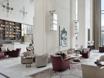 a lobby with chairs and tables in a building at Kempinski The Boulevard Dubai in Dubai