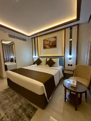 a hotel room with a large bed and a table at Smana Hotel Al Raffa in Dubai