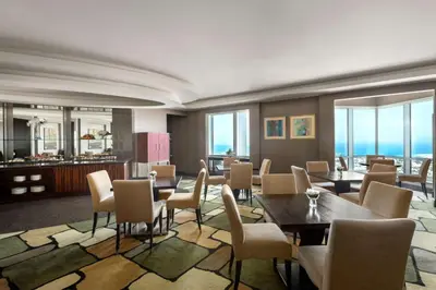 a dining room with tables and chairs and windows at Shangri-La Dubai in Dubai