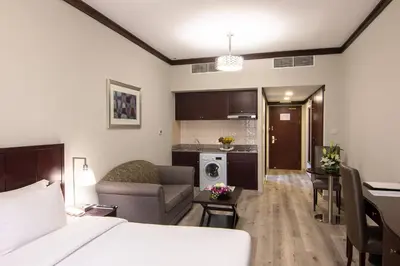 a hotel room with a bed and a living room at Savoy Crest Hotel Apartments in Dubai