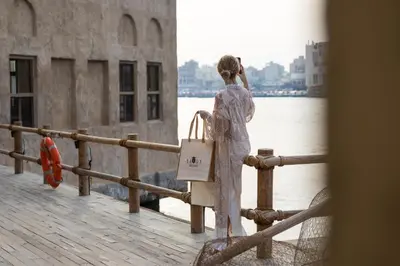 a woman standing on a pier looking at the water at Savoy Crest Hotel Apartments in Dubai