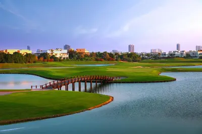 a golf course with a bridge over a body of water at Address Montgomerie in Dubai