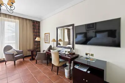 a hotel room with a desk and a mirror at Arabian Ranches Golf Club in Dubai