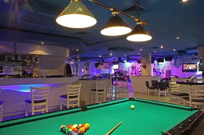 a pool table in a bar with chairs and lights at Sea View Hotel Dubai in Dubai