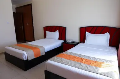 two beds sitting next to each other in a room at Wescott Plaza Hotel Apartments LLC Formerly West Zone Plaza Hotel Apts in Dubai