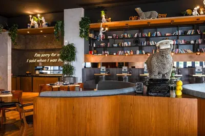 a bar at a restaurant with a bear statue on the counter at Media One Hotel in Dubai