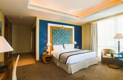 a bedroom with a large bed and a blue wall at Social Hotel in Dubai