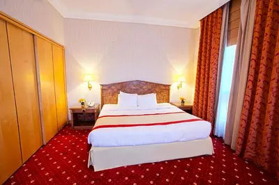 a bedroom with a large bed with a red carpet at Capitol Hotel Jumeirah Dubai in Dubai