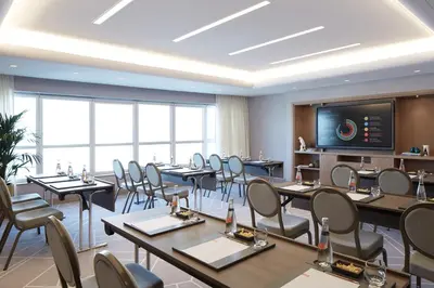 a restaurant with tables and chairs and a flat screen tv at Naumi Hotel Dubai in Dubai