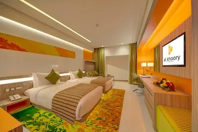 a large bedroom with two beds and a desk at Al Khoory Atrium in Dubai