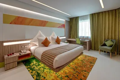 a hotel room with a large bed and a chair at Al Khoory Atrium in Dubai
