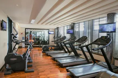 a gym with a row of treadmills at Centro Barsha - by Rotana in Dubai