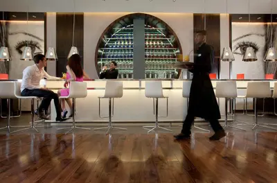 a group of people sitting at a bar in a restaurant at Centro Barsha - by Rotana in Dubai