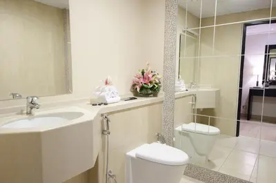 a bathroom with a sink and a toilet and a mirror at The Apartments, Dubai World Trade Centre in Dubai