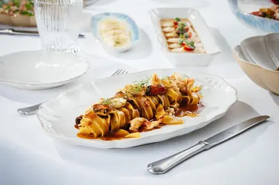 a white plate of food on a table at Aspen Chalets by Kempinski Hotel Mall of The Emirates in Dubai