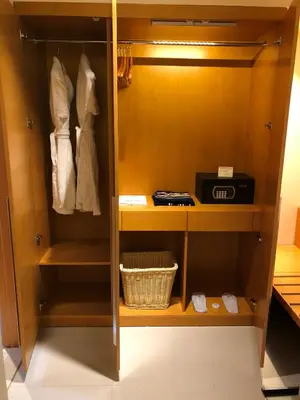 a closet with a wooden cabinet with a basket at Fortune Park Hotel in Dubai