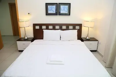 a bedroom with a large white bed with two lamps at Armada Living - Holiday Homes Rental in Dubai