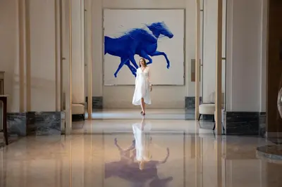 a woman standing in front of a painting of a horse at Jumeirah Al Naseem Dubai in Dubai