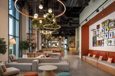 a lobby with couches and tables and a chandelier at Rove Bur Dubai - Healthcare City in Dubai