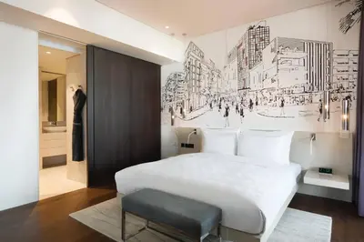 a bedroom with a white bed and a wall with a drawing at La Ville Hotel & Suites CITY WALK Dubai, Autograph Collection in Dubai