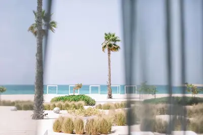 a view of a beach with palm trees and the ocean at Nikki Beach Resort & Spa Dubai in Dubai