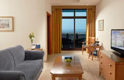 a living room with a couch and a table and a television at Roda Beach Resort in Dubai