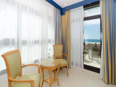 a room with a table and chairs and a balcony at Roda Beach Resort in Dubai