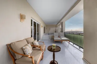 a living room with a balcony with a couch and a table at Al Habtoor Polo Resort in Dubai