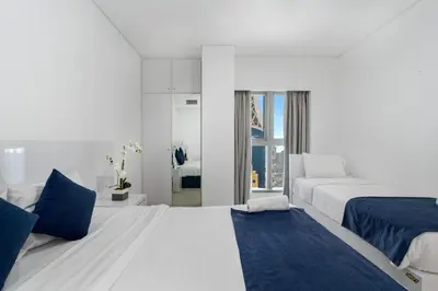 a white bedroom with two beds and a window at Princess Tower Dubai Marina private Spa amazing view in Dubai