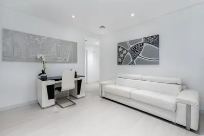 a white living room with a couch and a desk at Princess Tower Dubai Marina private Spa amazing view in Dubai